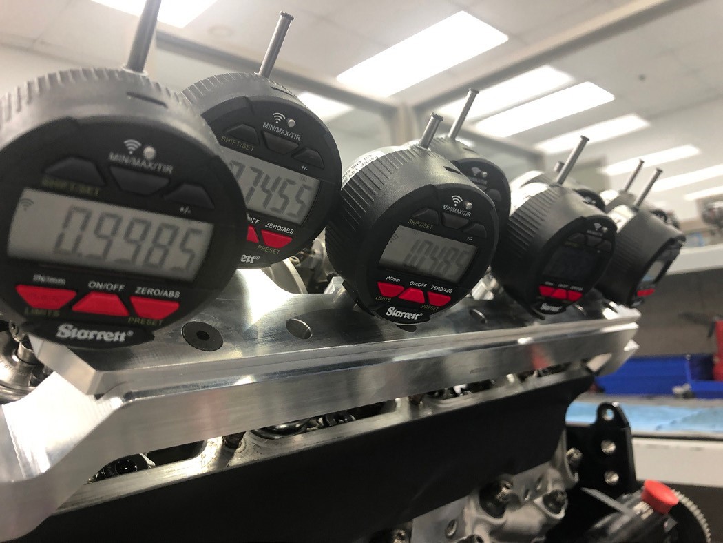 Multiple Starrett Digital Indicators in engine-mounted fixture capture and transmit T.I.R. measurement data to computer devices.